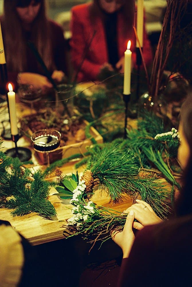 Adventskranz im Kerzenlicht, Hände beim Binden